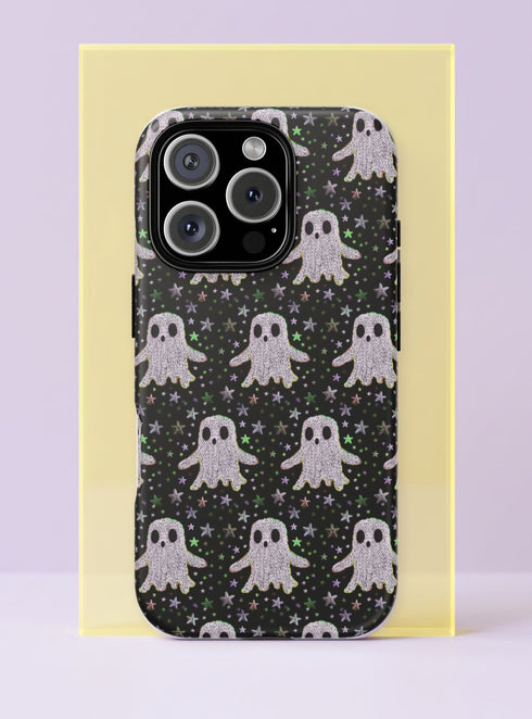 Front view of a dual layer tough phone case printed edge to edge with rows of kawaii ghosts on a black background. Each little ghost has a soft white and pale lilac knit style texture, wavy edges, and simple black oval eyes and mouth, floating among tiny stars in green, pink, purple, and silver. Cute, spooky, and cozy like a Halloween sweater. Creepy cute ghost phone accessory with open ports, dual layer protection, and a precise camera cutout.