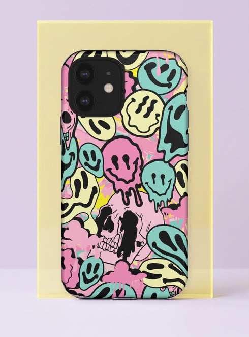 Front view of a dual layer tough phone case printed edge to edge with melting smiley faces. Drippy grinning smileys in mint, butter yellow, bubblegum pink, and baby blue pile on top of each other with bold black outlines and wobbly eyes, while a pink skull peeks out from the crowd near the bottom. Pink and yellow paint splatters fill the gaps. Trippy 90s pastel goth smiley phone accessory with a creepy cute twist, open ports, and a precise camera cutout.