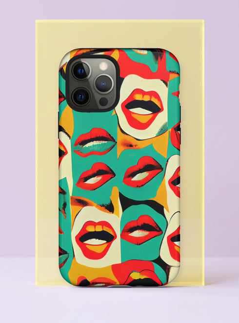 Front view of a dual layer tough phone case printed edge to edge with a pop art collage of mouths. Glossy red lips, open mouths with white teeth, and pouts in shades of cherry and coral repeat across patchwork blocks of teal, cream, mustard yellow, and orange, with a slightly worn screen print texture. It reads like a 60s magazine cut up and reassembled. Loud retro pop art lips phone accessory for big talkers, with open ports and a precise camera cutout.