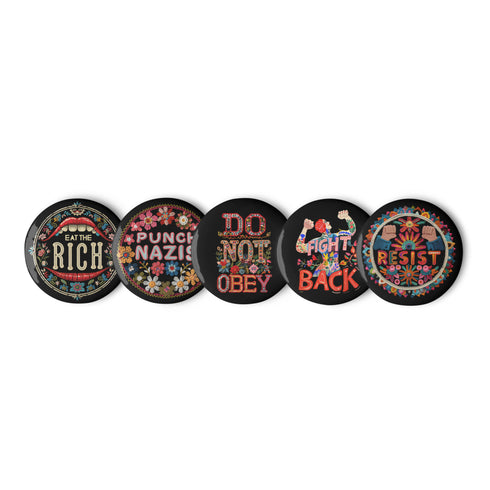A set of five round, glossy black pinback buttons with embroidered folk art designs and bold activist slogans. Each pin features a different phrase such as "Eat the Rich" and "Resist," surrounded by colorful floral motifs.