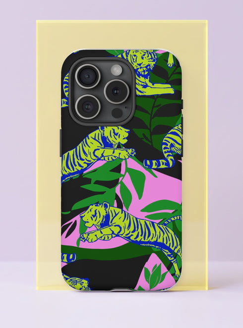 Front view of a dual layer tough phone case printed edge to edge with a psychedelic jungle scene. Chartreuse tigers with electric blue stripes leap and lounge across the case through big tropical leaves in emerald and forest green, set on a split background of black and orchid pink. Bold flat shapes and high contrast color give it a 70s poster feel. Maximalist tropical tiger phone accessory with open ports and a precise camera cutout.