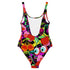 A colorful one-piece swimsuit features a vibrant, quirky pattern with cherries, cartoon eyes, and playful designs on a dark background.