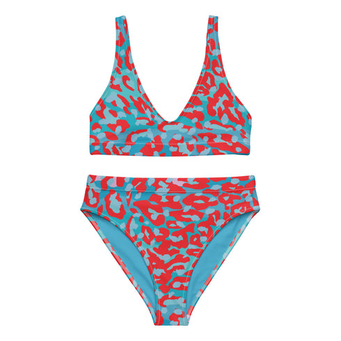 Vibrant two-piece leopard print swimsuit with abstract red and teal pattern. Sports bra-style top and high-waisted bottoms. Purple background. Tag visible. Trendy, colorful beachwear for modern style.