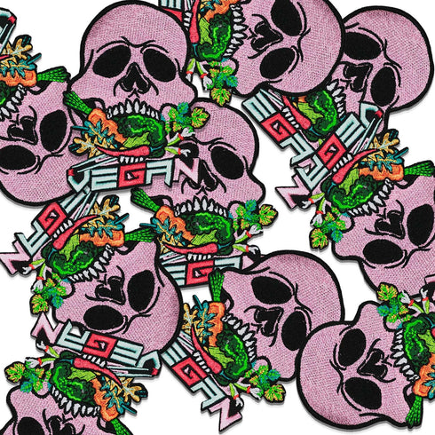 Patch featuring a pink skull biting into colorful vegetables with the word 'VEGAN' in bold letters below, set against a black background. The design is vibrant and edgy, blending vegan pride with a punk rock aesthetic.