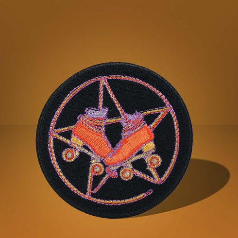 Patch featuring orange roller skates over a purple pentagram, set against a black background. The design combines playful skating elements with a mystical, witchy twist.