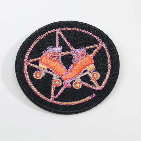 Patch featuring orange roller skates over a purple pentagram, set against a black background. The design combines playful skating elements with a mystical, witchy twist.