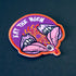 Patch featuring the text 'Eat The Rich' above a design of two open mouths with fangs and a tongue holding an eyeball, set against a purple background with an orange border. The design is bold and edgy.