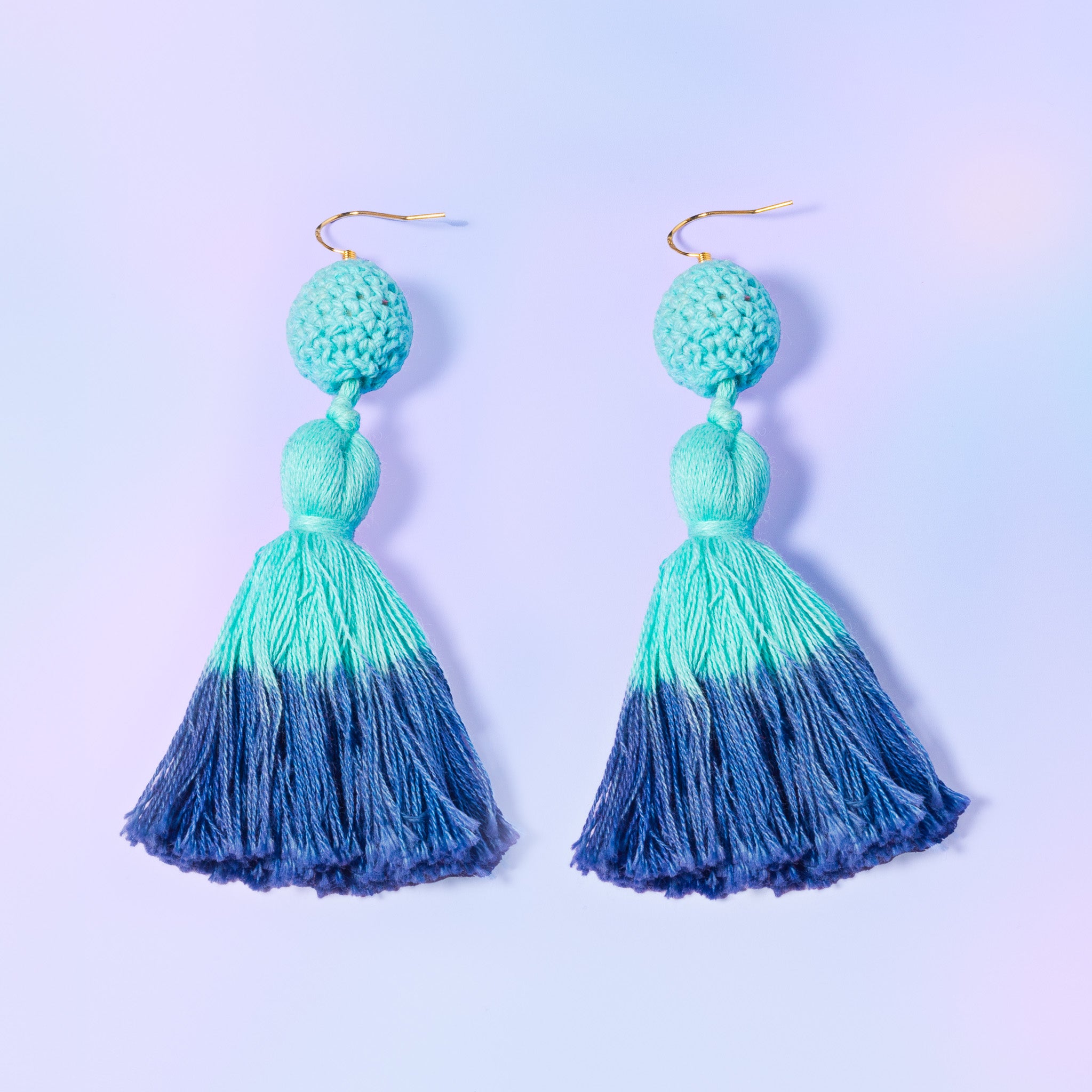 a pair of blue and green tasselled earrings