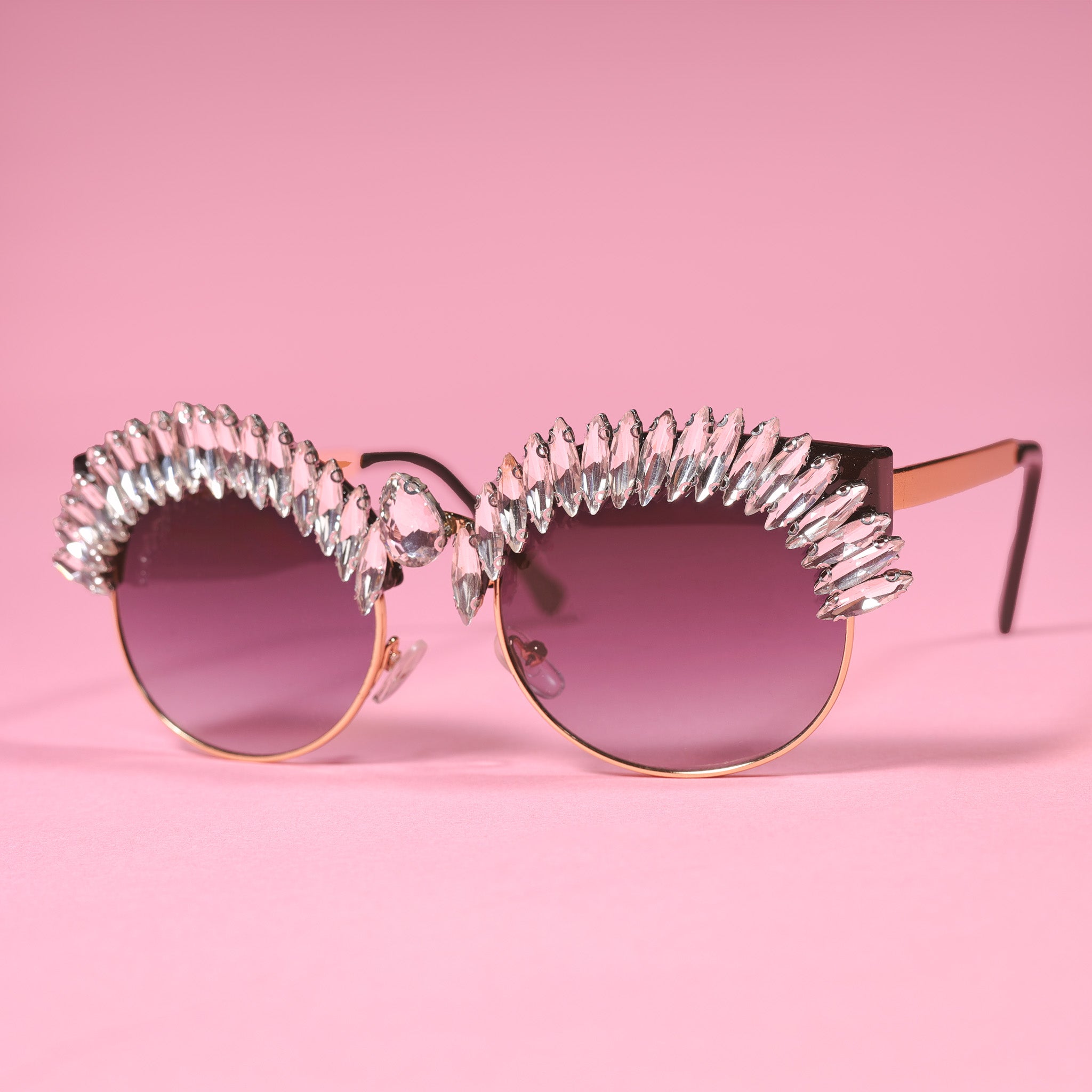 a pair of sunglasses with a pink background