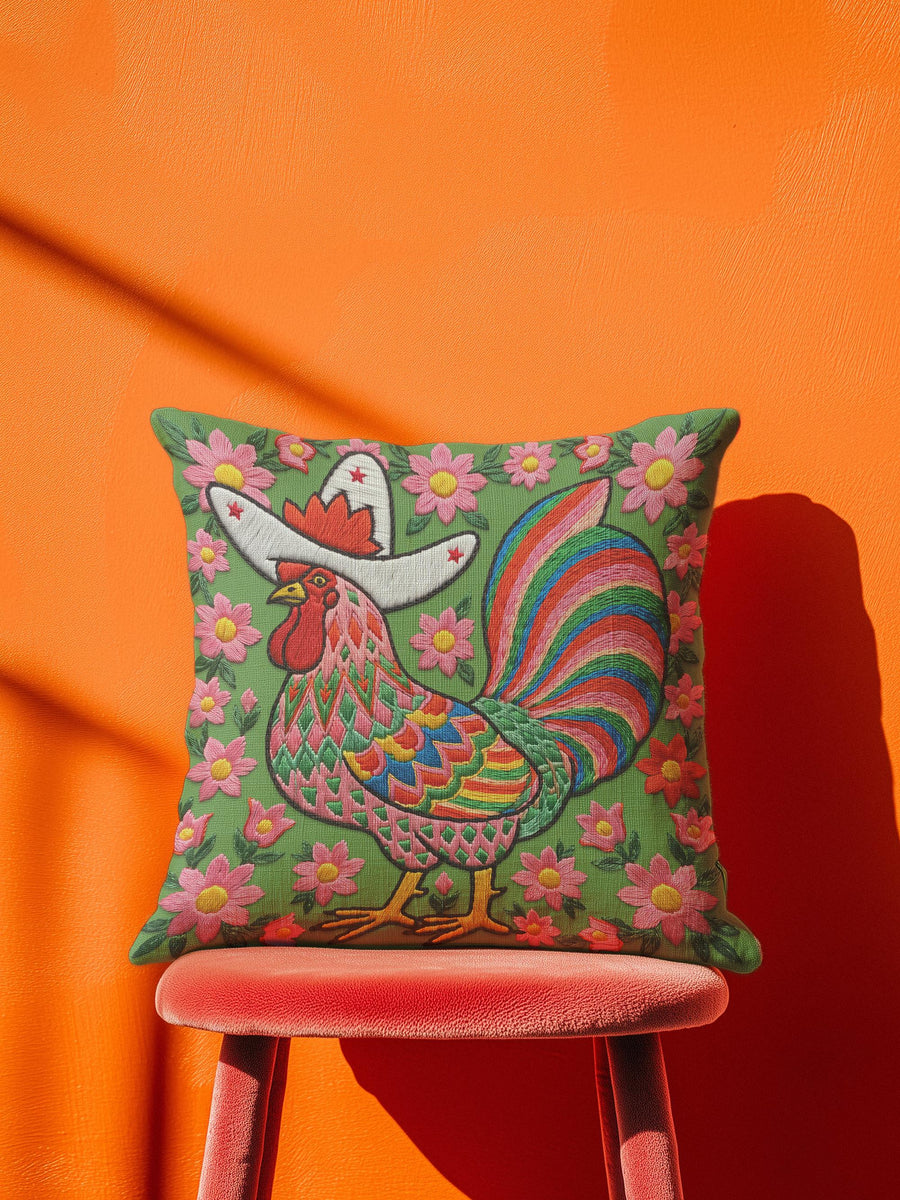 Square throw pillow cover with a printed faux embroidery design of a rooster wearing a white cowboy hat with red stars on a grass green background. The western chicken has a red comb and wattle, yellow beak and feet, and layered feathers in pink, green, orange, blue, and yellow with a rainbow striped tail. Pink and red flowers with yellow centers frame the bird. The stitched look is a flat 2D print on a smooth linen feel polyester cover with a hidden zipper, not raised embroidery.