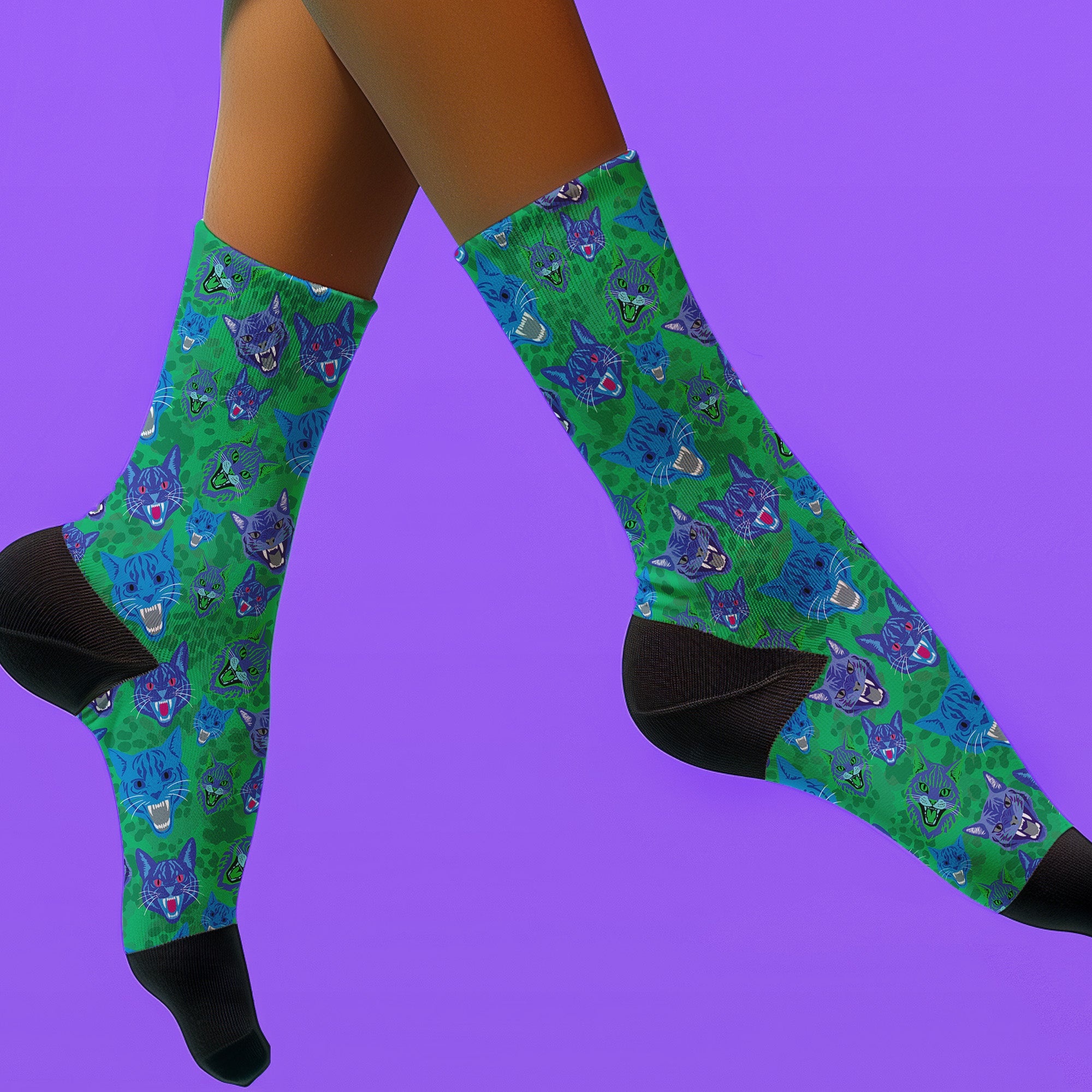 Fun and playful socks adorned with vibrant tiger head motifs on a green background, with black heels and toes, ideal for animal lovers and those who enjoy unique designs