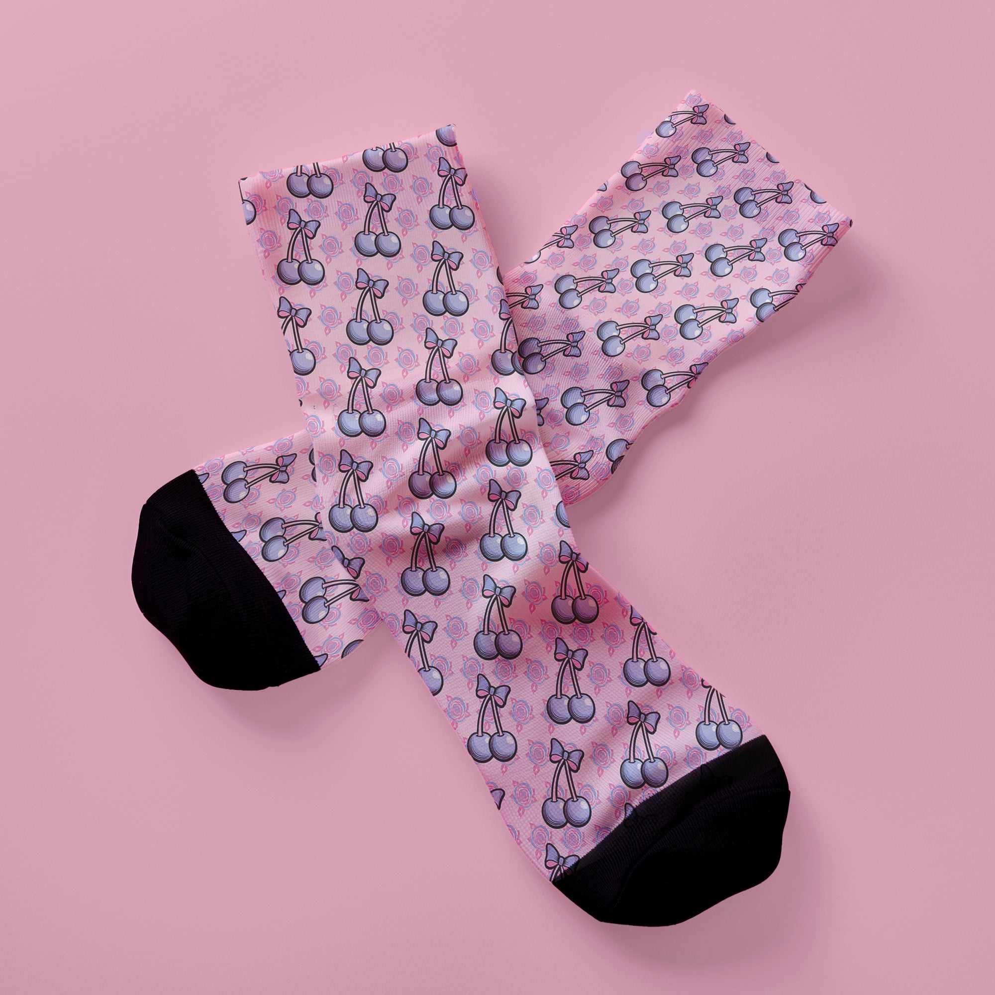 Fun and playful cherry bow-patterned pink socks with black heels and toes,  ideal for those who love quirky and cute designs
