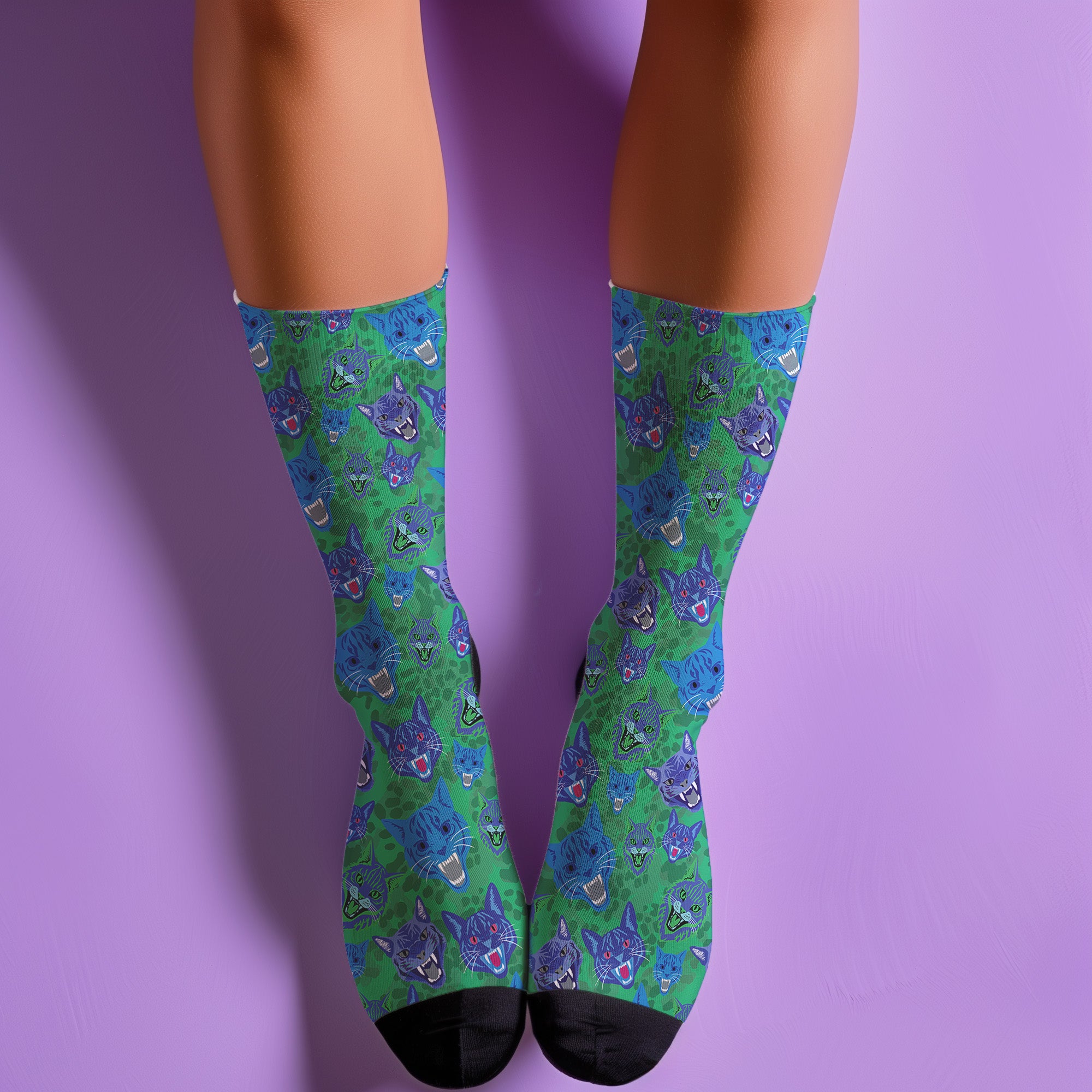 un and playful socks adorned with vibrant tiger head motifs on a green background, with black heels and toes, ideal for animal lovers and those who enjoy unique designs
