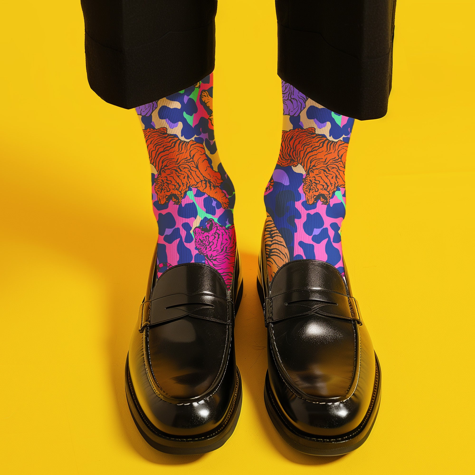 Stylish jungle-themed socks with tigers and abstract camo patterns in a palette of purple, blue, and pink, laid out on a yellow background, ideal for adding a pop of color to your wardrobe