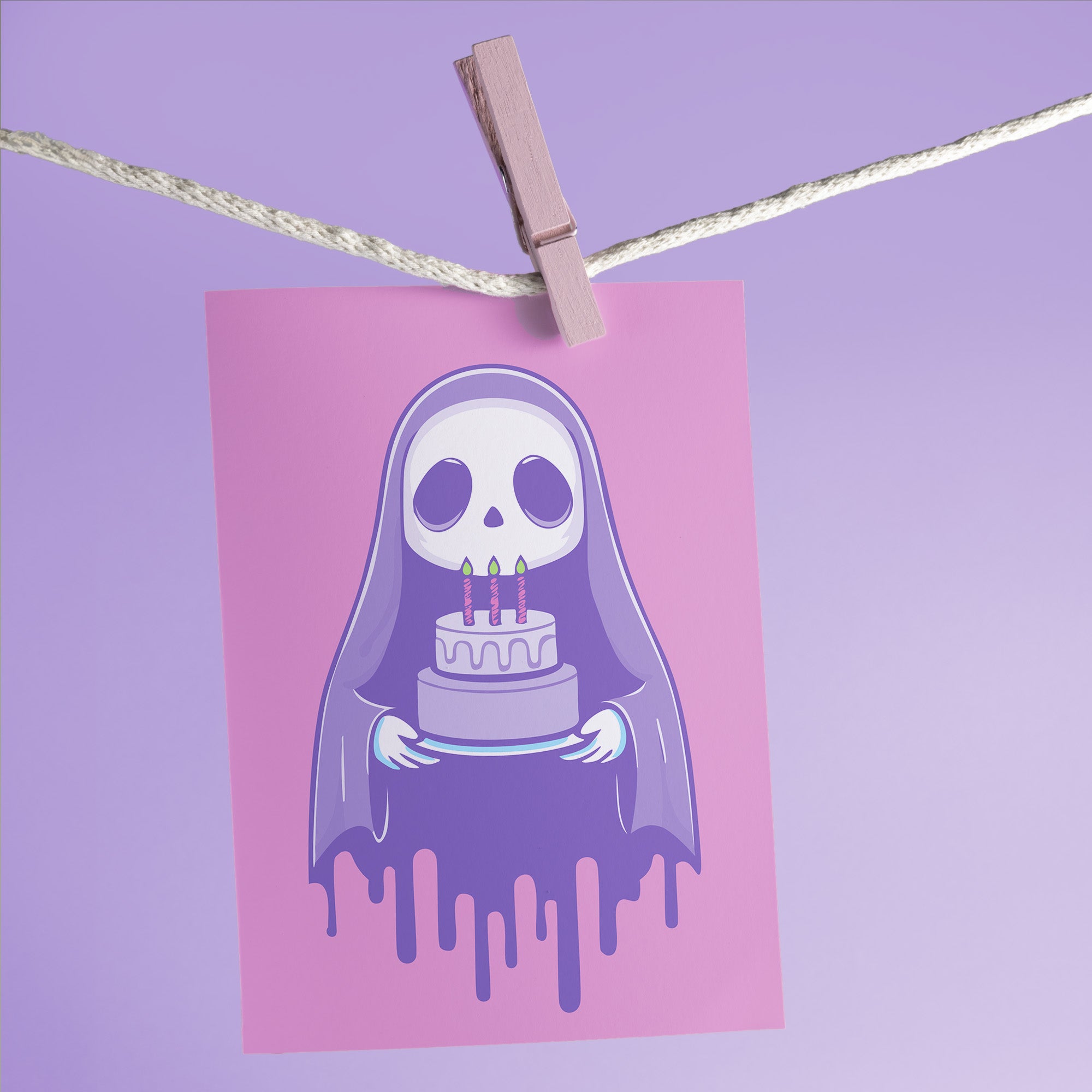 Birthday card featuring a cute cartoon grim reaper holding a birthday cake on pink background. The reaper wears a purple cloak and has a white skull face. It's carrying a small purple cake with three lit candles. The reaper's cloak drips like melting icing at the bottom. Ideal for Halloween birthdays or gothic-themed celebrations. Inside greeting: 