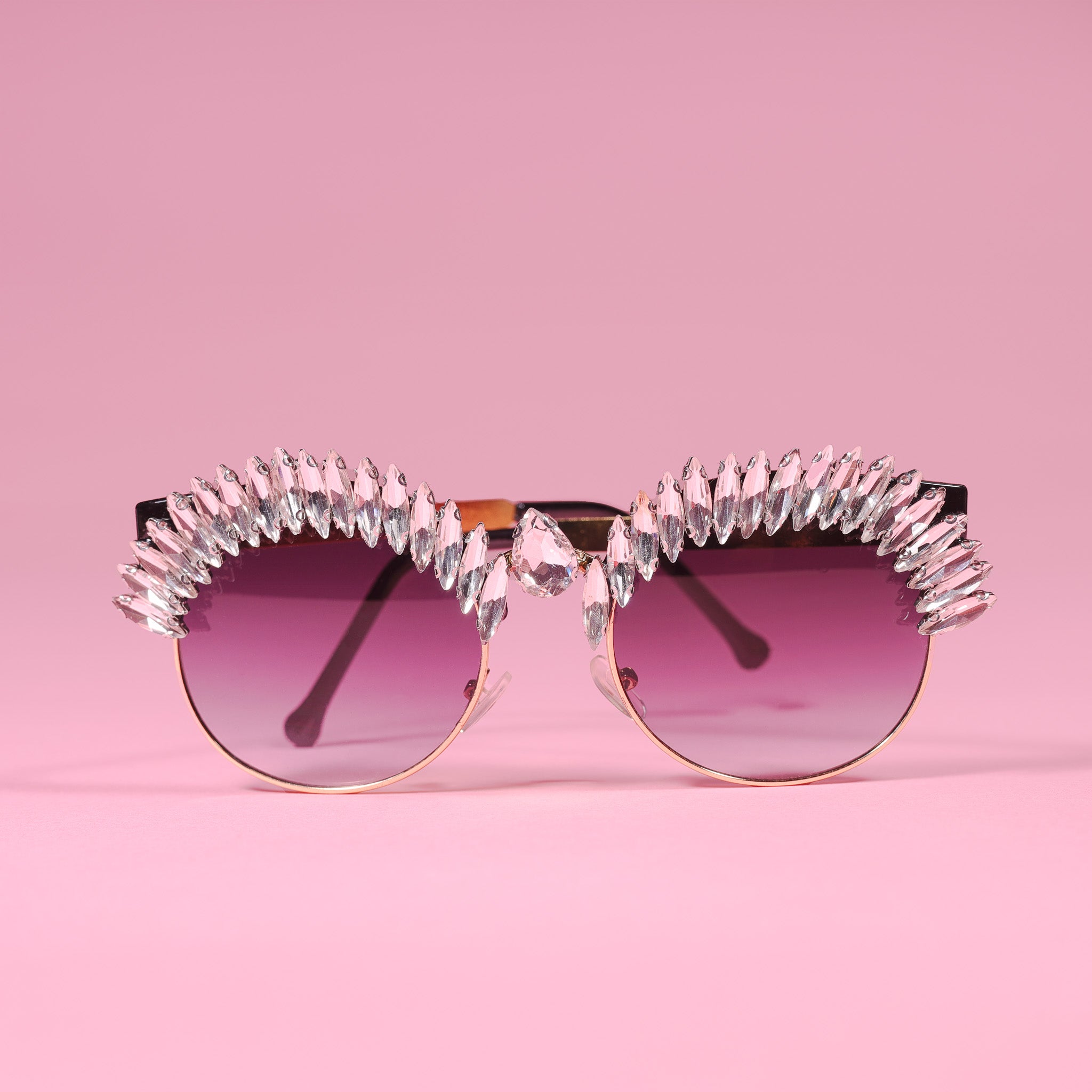 a pair of sunglasses with a pink background