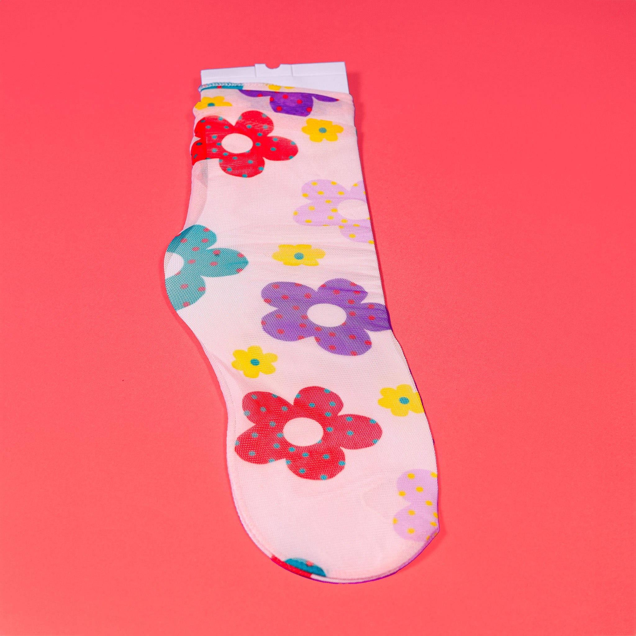 a white sock with flowers on it on a pink background