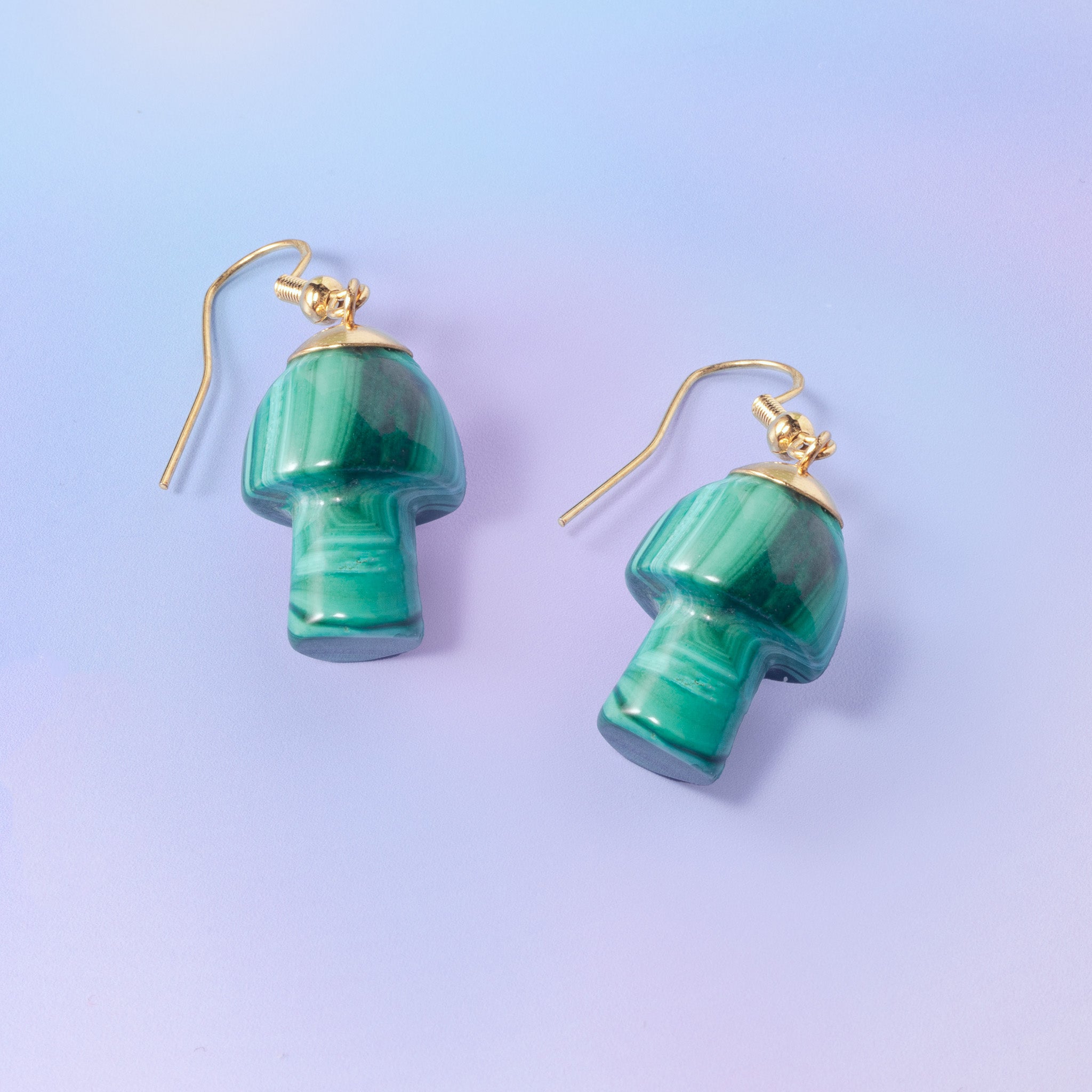 a pair of green earrings on a blue background