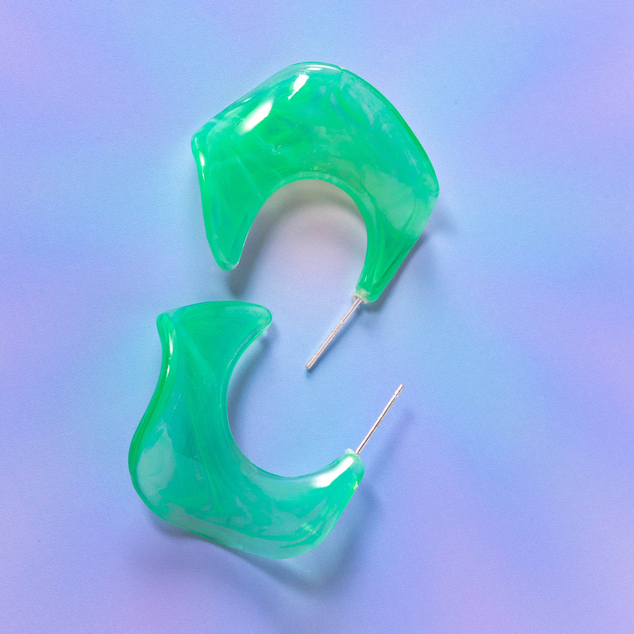 a pair of green earrings sitting on top of a table